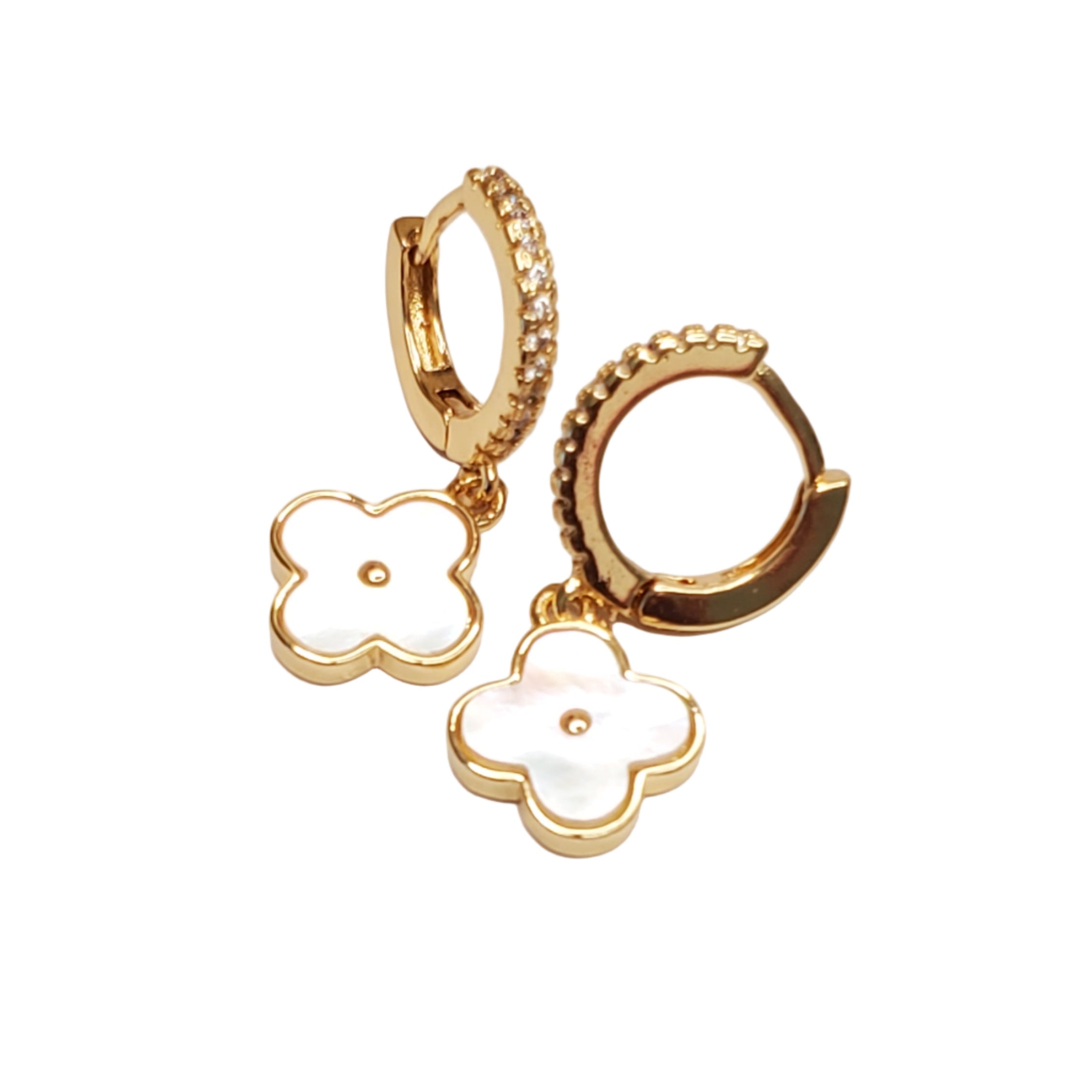 Gold hoop earrings with mother of pearl clover charms on a light gray background
