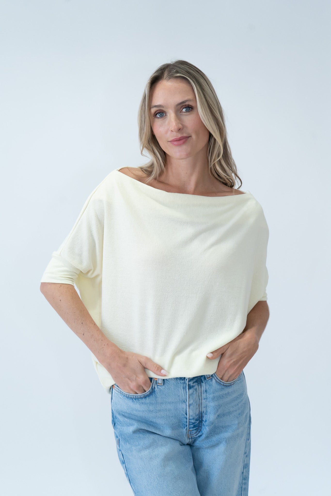 woman wearing a  pale yellow off the shoulder short sleeve top.